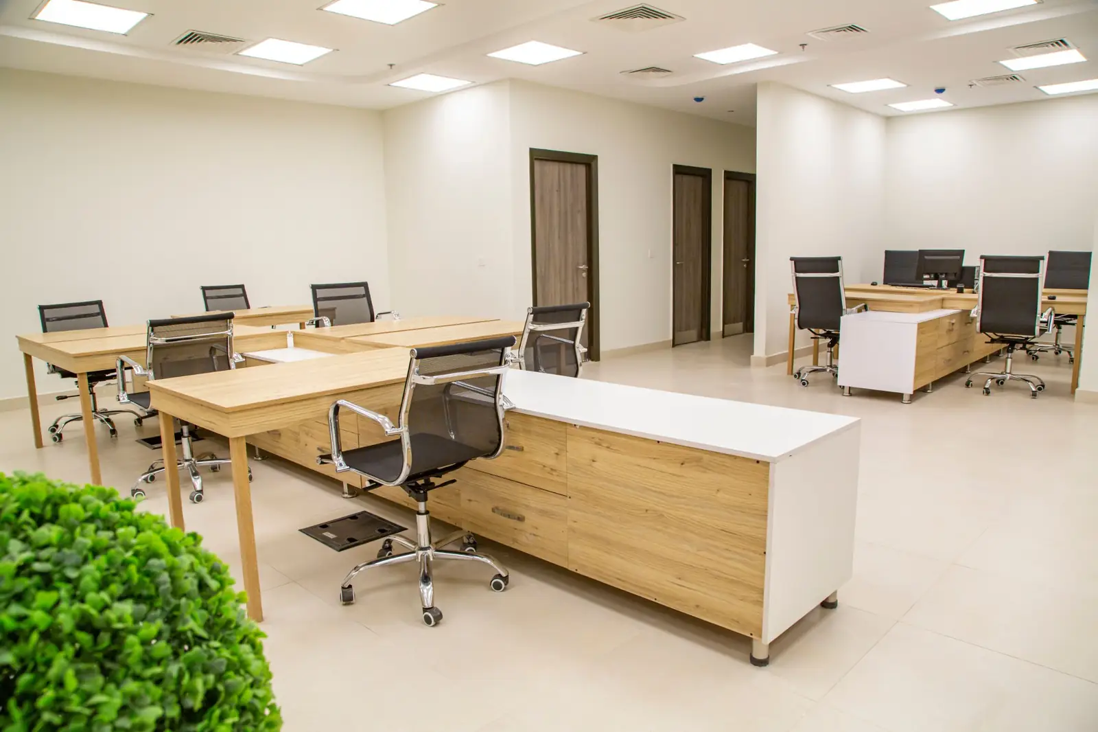 Open-plan office with clean desks and tile floors